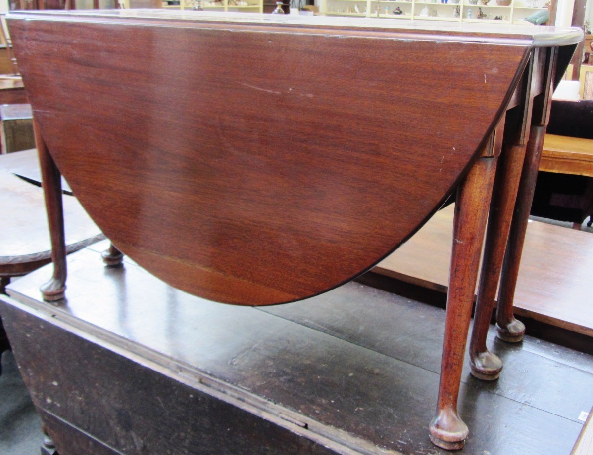 Appraisal: A mid th century mahogany oval drop flap table on