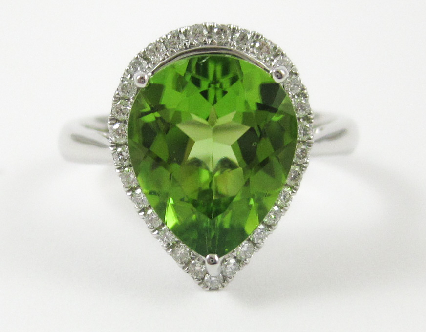 Appraisal: PERIDOT DIAMOND AND FOURTEEN KARAT WHITE GOLD RING with round-cut