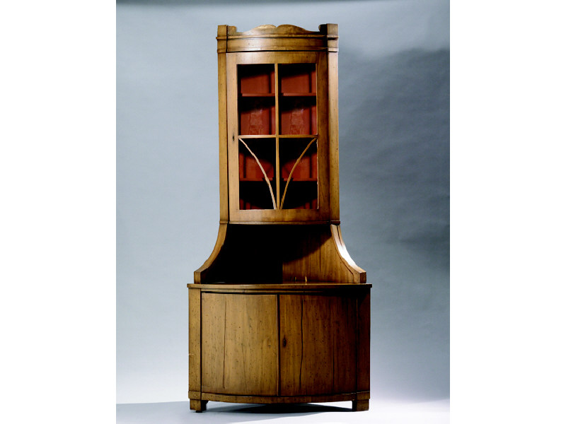 Appraisal: CONTINENTAL TWO PIECE CONVEX CORNER CABINET Showing a rolling crest