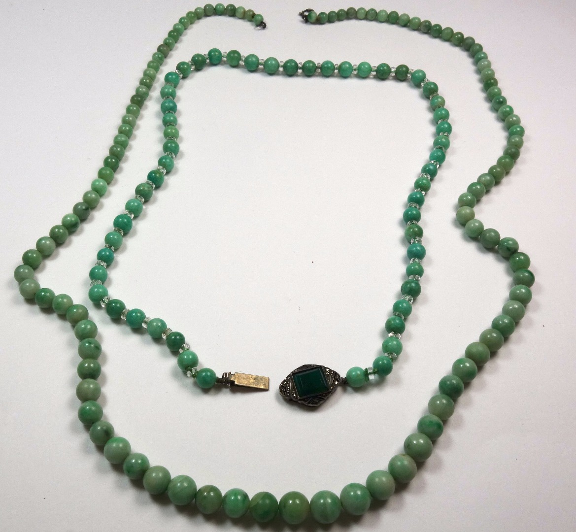 Appraisal: A pale green mottled jadeite necklace the round beads graduated