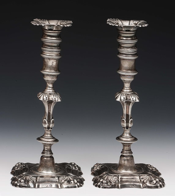 Appraisal: A pair of Georgian Irish silver candlestickson square cut platform