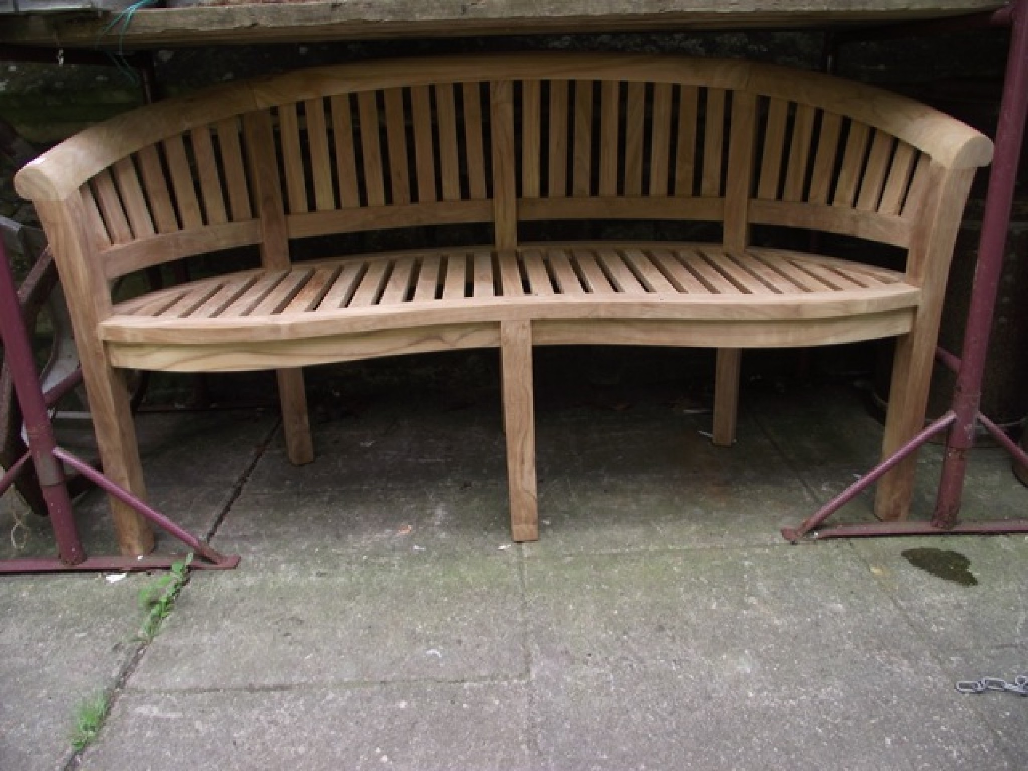 Appraisal: A contemporary teak 'banana' bench to be sold with the