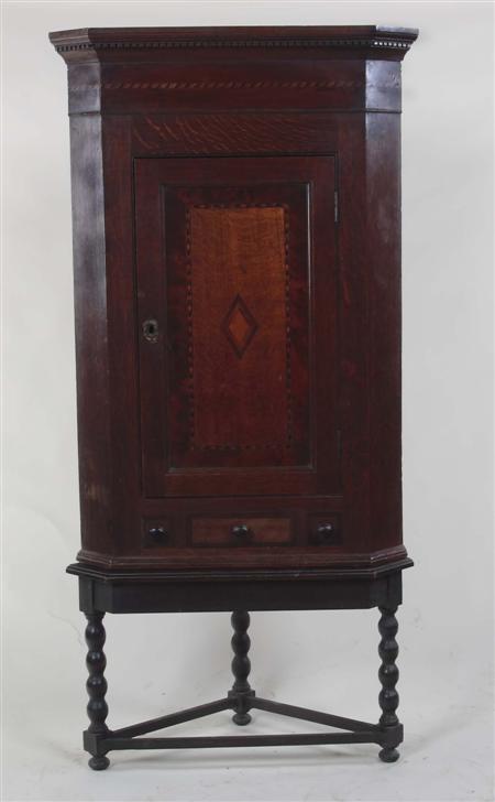 Appraisal: A George III oak corner cupboard on stand the projected