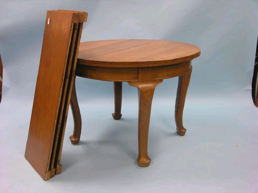 Appraisal: A solid walnut extending dining table circular top with three