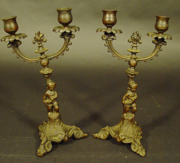 Appraisal: Pair of bronzed metal two branch candelabra supported by figures