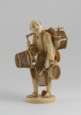 Appraisal: A Japanese ivory carving of a basket seller carrying a