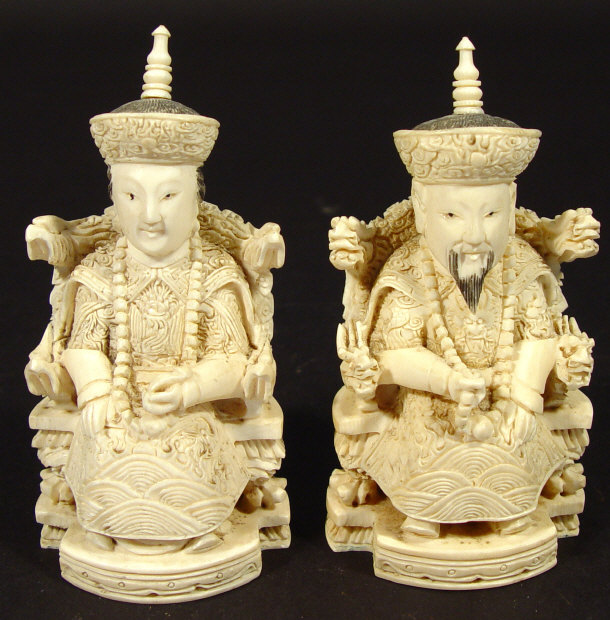 Appraisal: Pair of oriental carved ivory figures on thrones each with