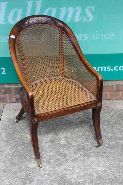 Appraisal: A REGENCY MAHOGANY AND BRASS INLAID BERGERE LIBRARY CHAIR with