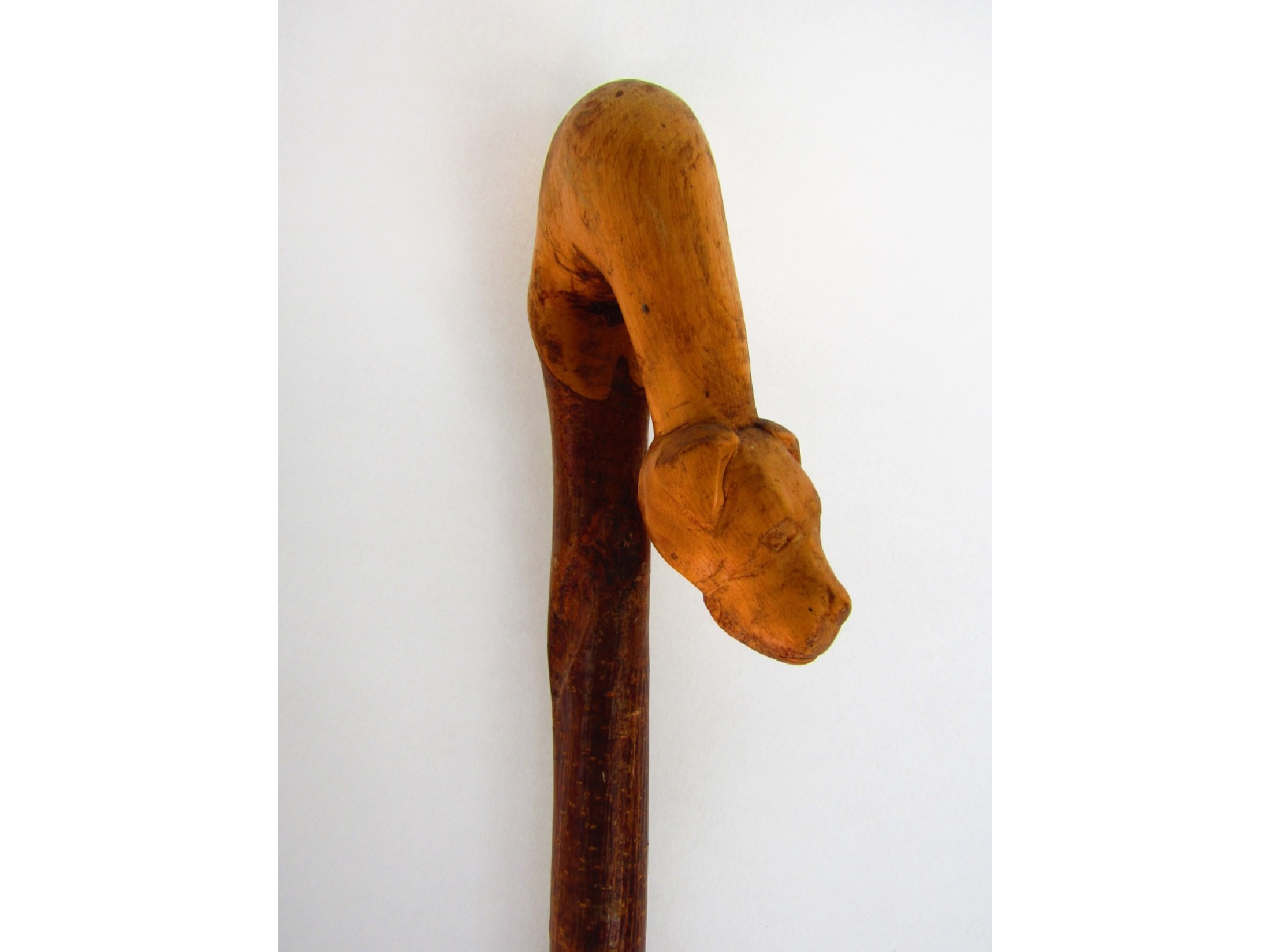 Appraisal: A rustic ashwood crook terminating in a carved dog mask