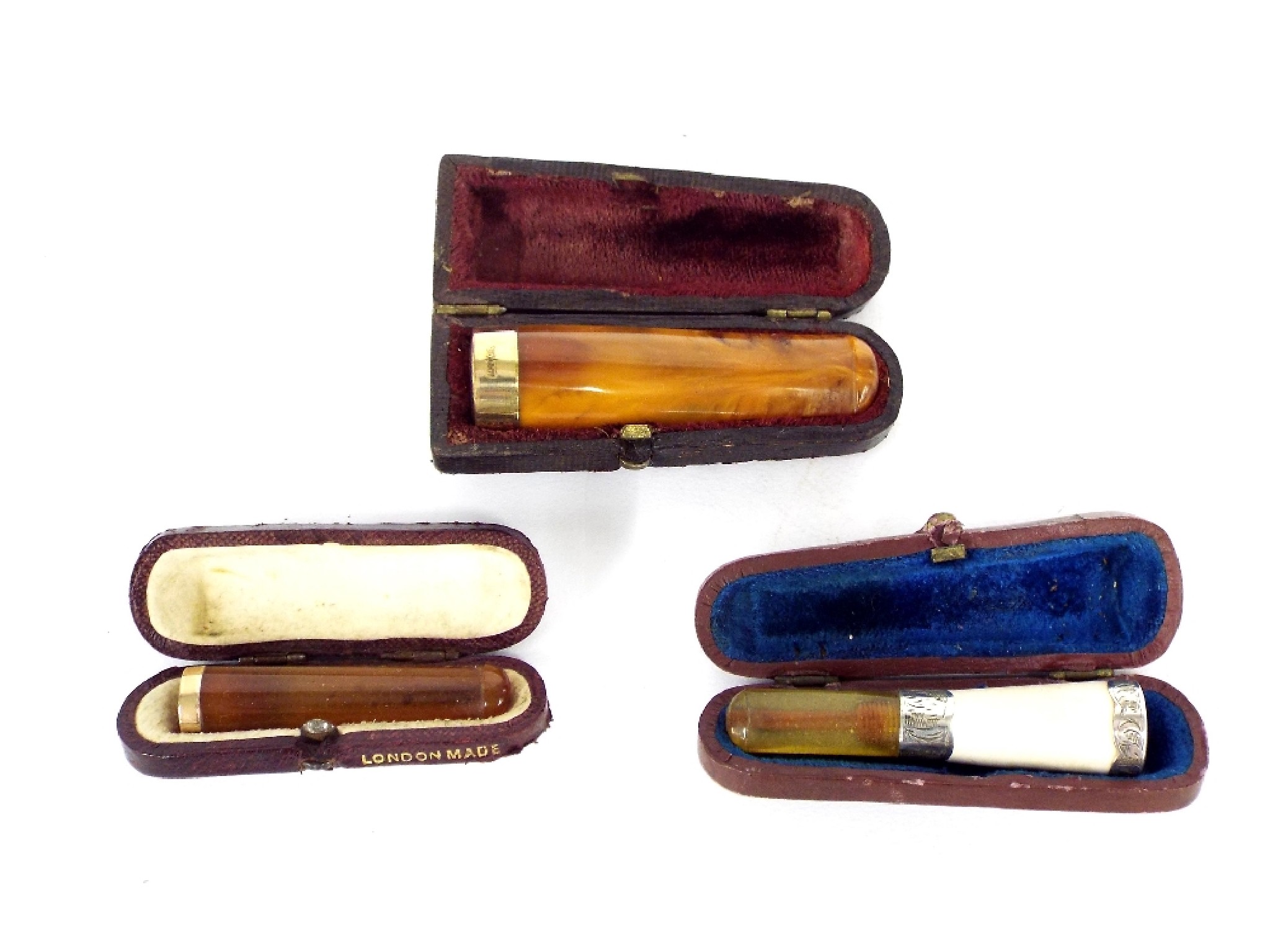 Appraisal: Three cased amber cheroot holders two with ct gold collar