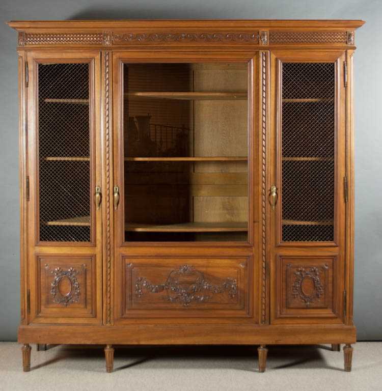 Appraisal: LOUIS XVI STYLE CARVED WALNUT CABINET BOOKCASE French c a