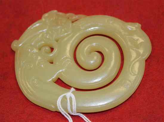 Appraisal: A Chinese yellow jade plaque carved as an archaistic chi-dragon