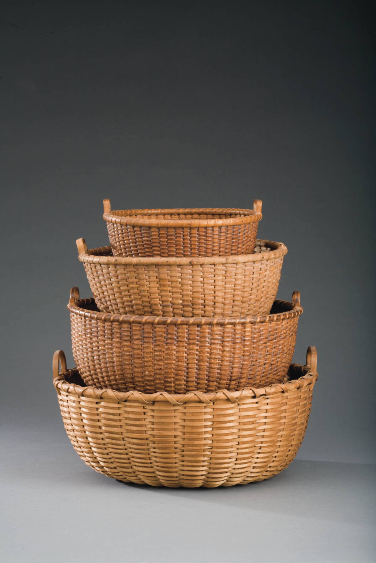 Appraisal: CIRCULAR TWO-HANDLED NANTUCKED BASKET The shaped handles secured to the