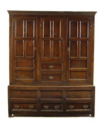 Appraisal: An oak wardrobe the moulded cornice above three panelled doors