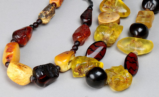 Appraisal: A ROUGH CUT GRADUATED AMBER BEAD NECKLACE with varying coloured