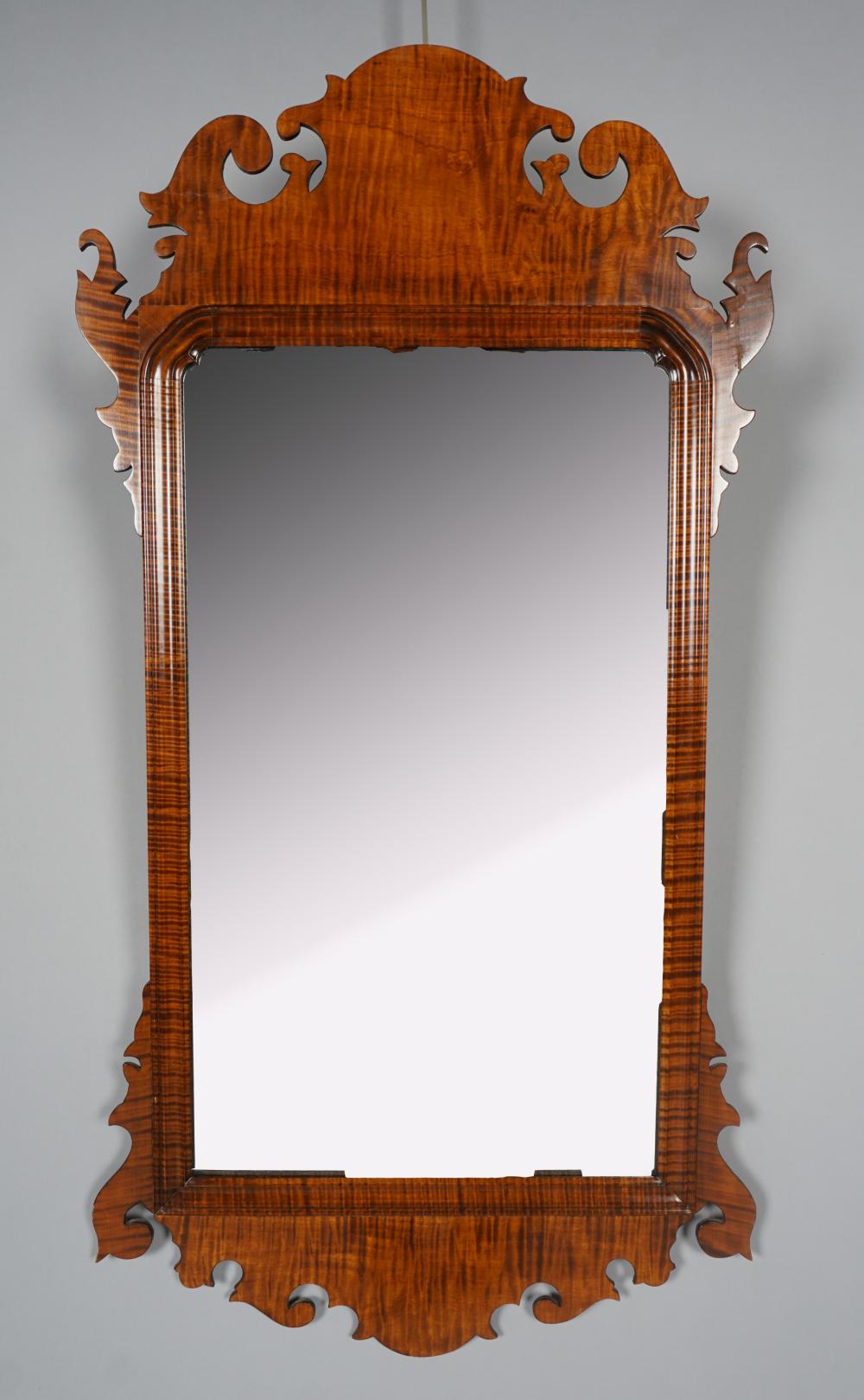 Appraisal: CHIPPENDALE STYLE FIGURED MAPLE SCROLL-CUT MIRROR the rectangular plate in