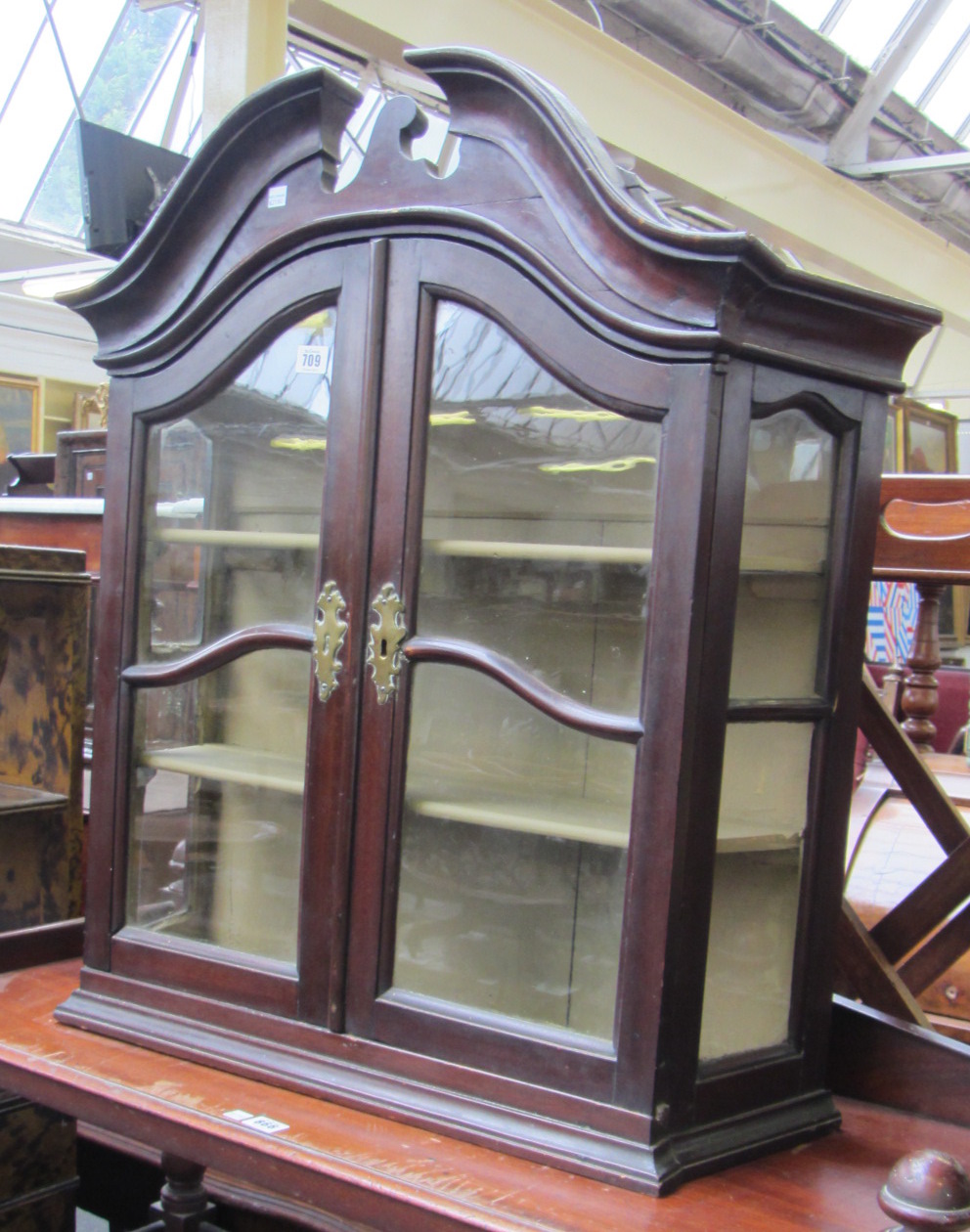 Appraisal: An th century Dutch mahogany bonnet topped hanging wall cabinet