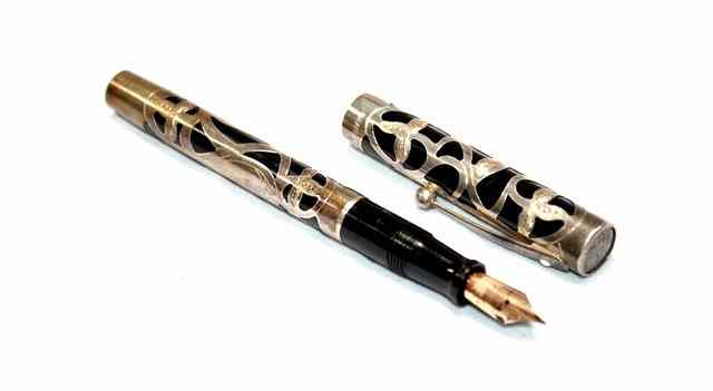 Appraisal: A SHEAFFER NOSTALGIA HARD RUBBER AND SILVER OVERLAY FOUNTAIN PEN