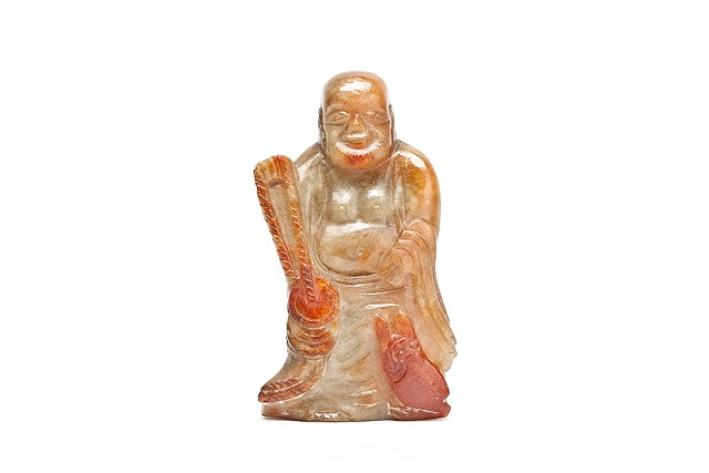 Appraisal: A CHINESE GREEN AND RUST TINTED JADE FIGURE OF A