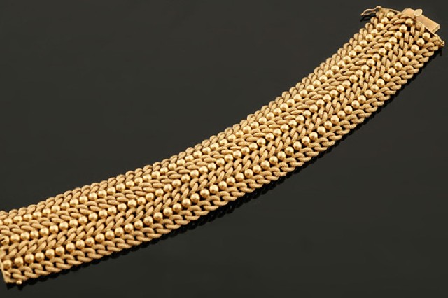 Appraisal: A gold cocktail bracelet The wide bracelet having alternating rows