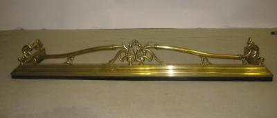 Appraisal: AN EDWARDIAN BRASS FIRE FENDER of moulded oblong form surmounted