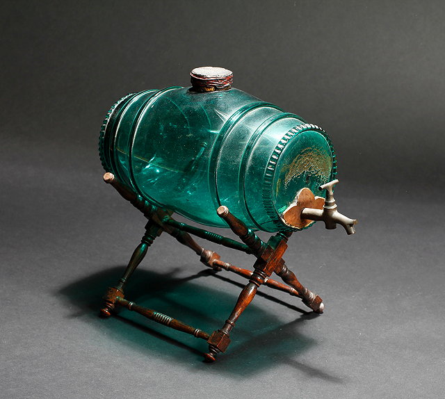 Appraisal: A CONTINENTAL GREEN GLASS SPIRIT BARREL with brass tap and