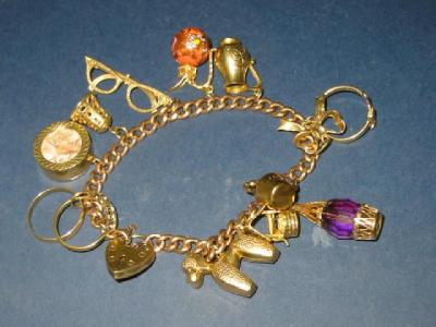 Appraisal: A CT GOLD CHARM BRACELET the flattened curb link hanging