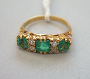 Appraisal: A gold emerald and diamond set ring mounted with three