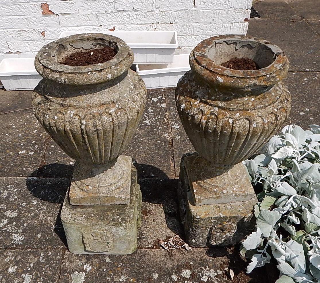 Appraisal: A pair of reconstituted stone urn shaped garden vases with