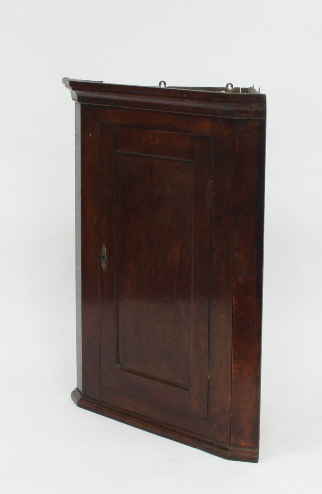 Appraisal: An oak hanging corner cupboard with panelled door cm ''