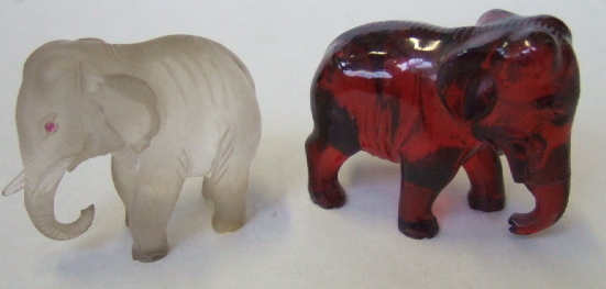 Appraisal: A carved amberoid elephant and a carved crystal elephant th