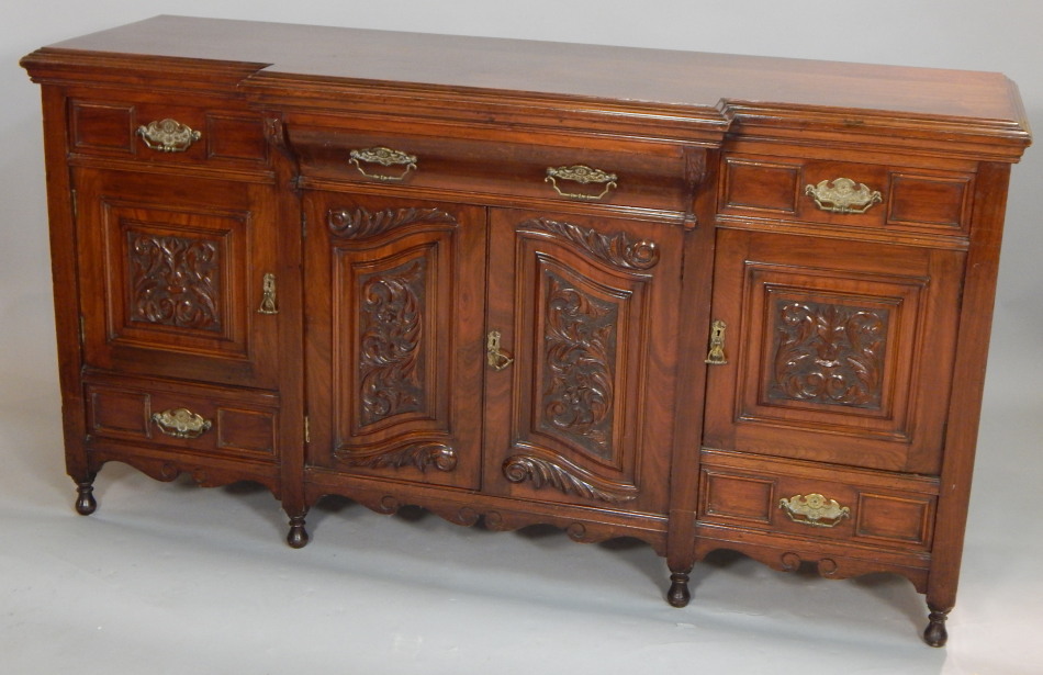 Appraisal: A late Victorian carved walnut breakfront sideboard with three frieze