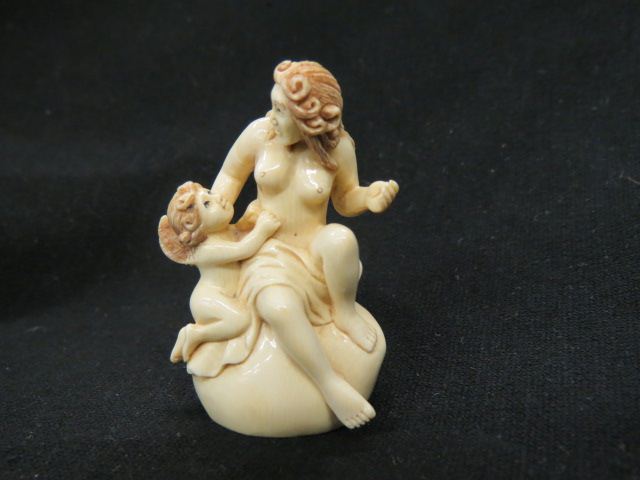 Appraisal: Carved Ivory Netsuke of Seated Nude cherub at her side