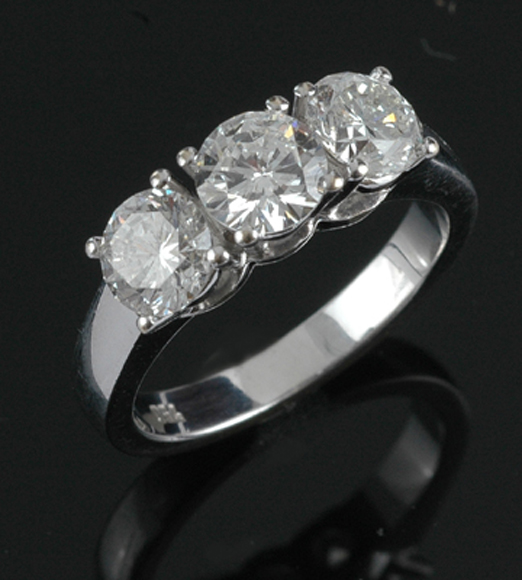 Appraisal: A three stone diamond ring Centrally set with a round