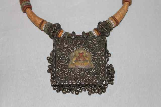 Appraisal: AN INDIAN NECKLACE with embossed silver metal large square pendant