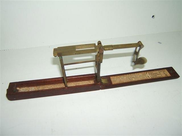 Appraisal: A GEORGE III MAHOGANY AND BRASS FOLDING GUINEA SCALE with