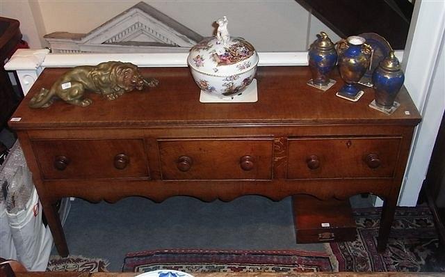 Appraisal: A GEORGE III OAK DRESSER BASE fitted three drawers with