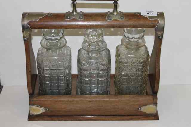 Appraisal: A VICTORIAN OAK THREE BOTTLED TANTALUS and a claret jug