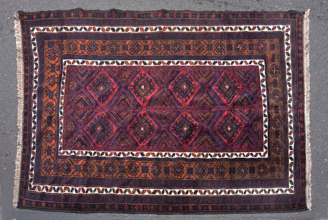 Appraisal: A BELOUCH DARK BLUE AND RED GROUND RUG with central