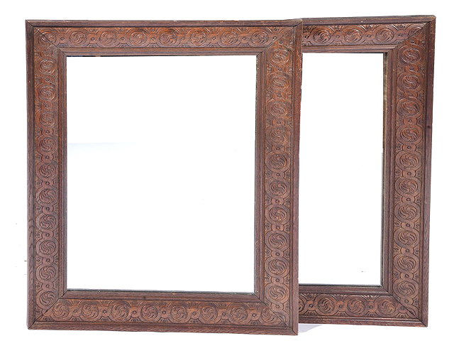 Appraisal: A PAIR OF RECTANGULAR OAK FRAMED WALL MIRRORS with carved