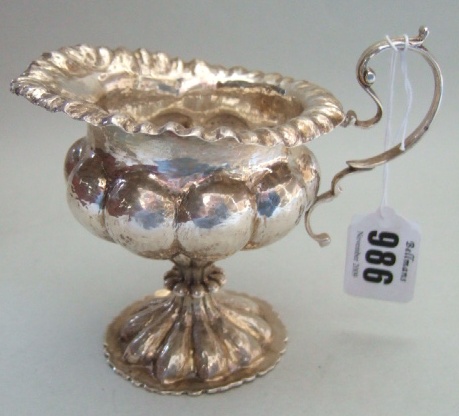 Appraisal: A silver milk jug with planished lobed decoration with a