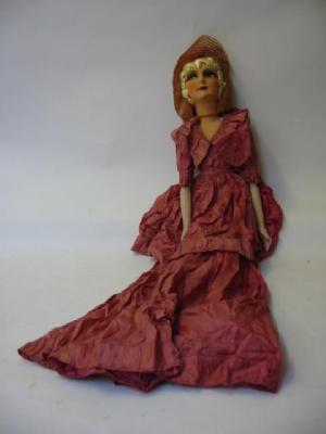 Appraisal: A boudoir doll with moulded and painted fabric face gold