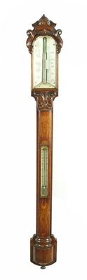 Appraisal: A Victorian oak stick barometer with a carved cresting above