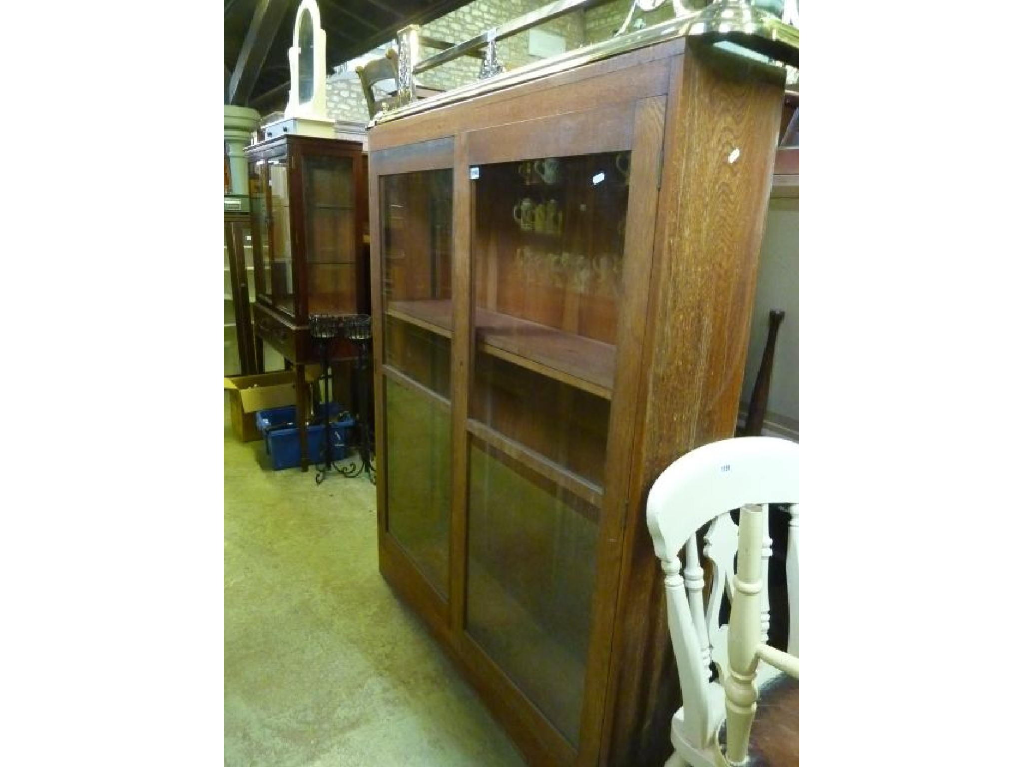 Appraisal: An oak bookcase enclosed by two glazed panelled doors with