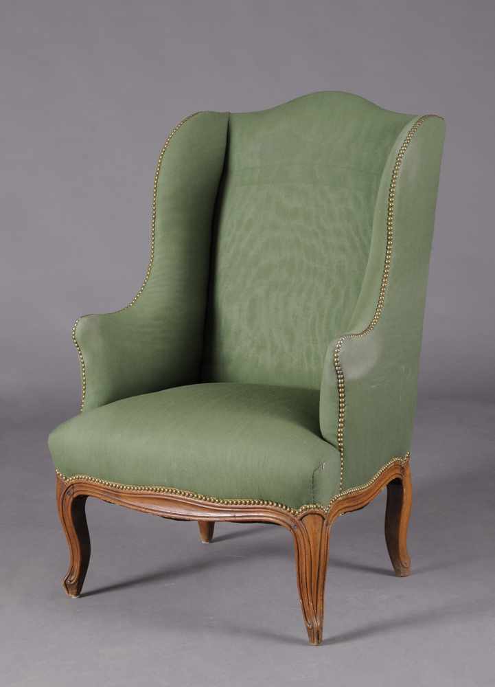 Appraisal: LOUIS XV PROVINCIAL BEECHWOOD WINGED ARMCHAIR The arched top rail