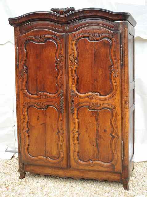 Appraisal: A CONTINENTAL DARK STAINED ARMOIRE the shaped cornice with carved