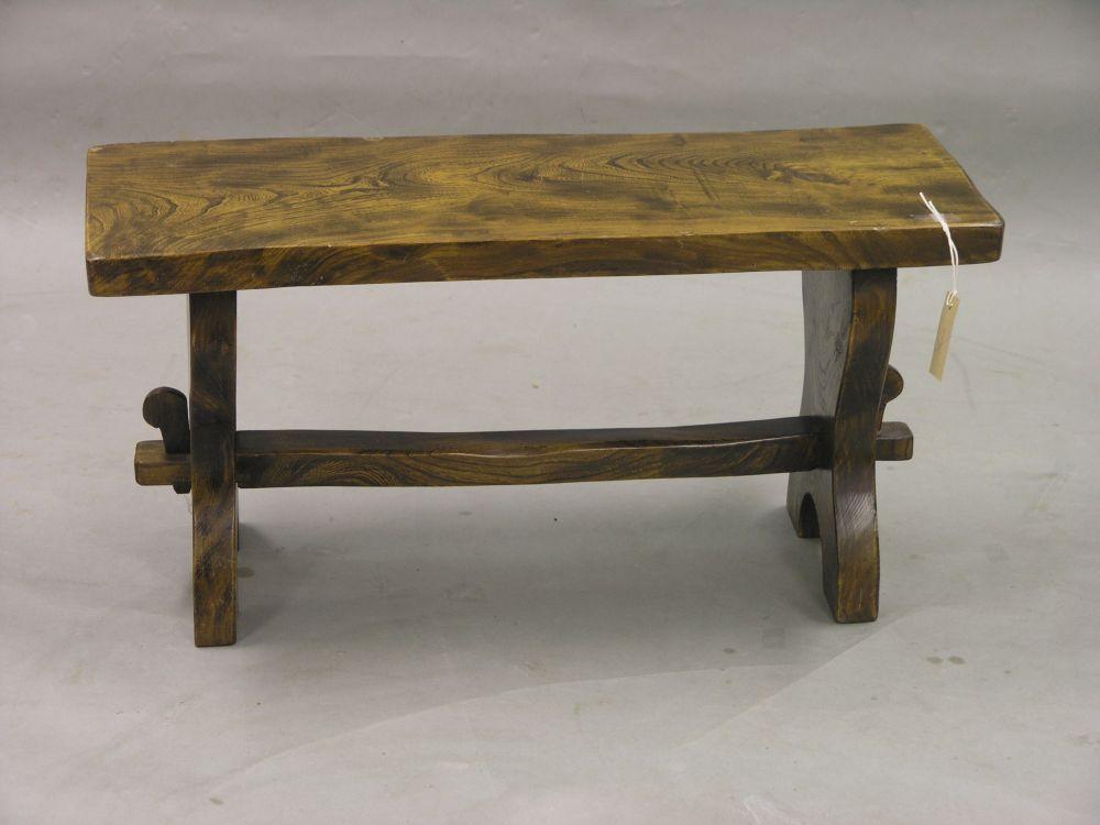 Appraisal: An elm two seat stool on end supports with stretcher