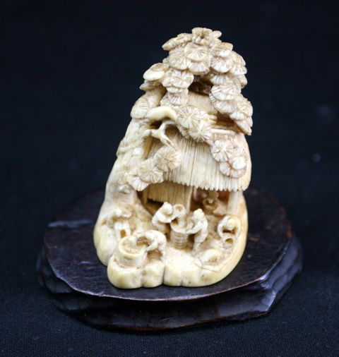 Appraisal: A Japanese carved ivory okimono modelled as figures before a