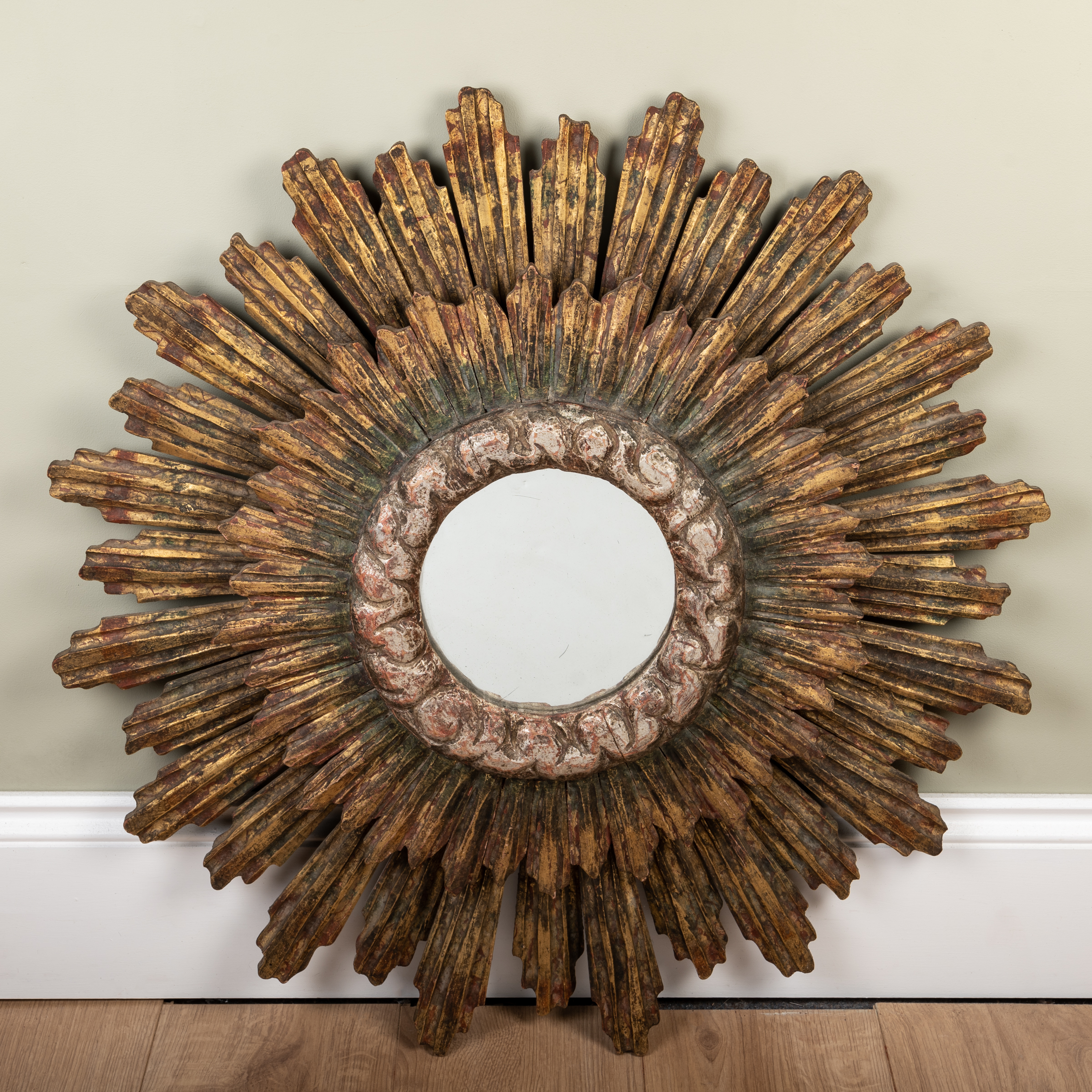 Appraisal: A decorative gilt carved wood wall mirror of circular radiating