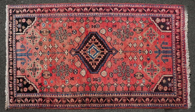 Appraisal: An Iranian red ground wool rugwith floral and geometric designs